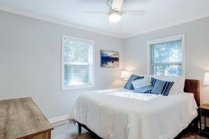 - une chambre blanche avec un lit et 2 fenêtres dans l'établissement Barefoot Lizzy's, à Edisto Island