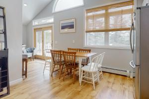 a kitchen and dining room with a table and chairs at Deer Run Retreat in Gilford
