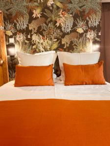 um quarto com uma cama com almofadas laranja e branca em Bastide Sainte Trinide em Sanary-sur-Mer