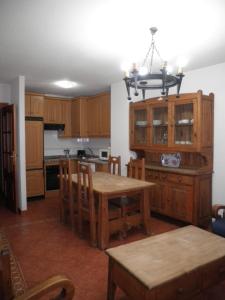 a kitchen with wooden cabinets and a table with a dining room at Apartamentos Anita in La Alberca
