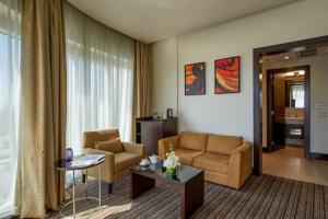 a living room with a couch and a table at Safir Hotel Doha in Doha