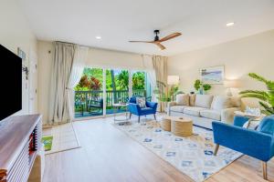 a living room with blue chairs and a couch at Poipu Mermaid 912 in Koloa