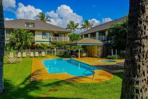 a house with a swimming pool in a yard at Poipu Mermaid 912 in Koloa