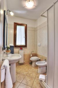 La salle de bains est pourvue de 2 lavabos, de toilettes et d'une douche. dans l'établissement Alberese Casa Vacanze, à Alberese