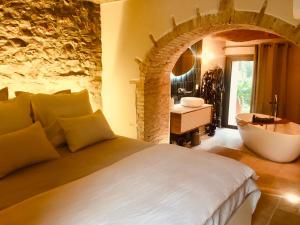 a bedroom with a large bed and a bath tub at Bastide Sainte Trinide in Sanary-sur-Mer