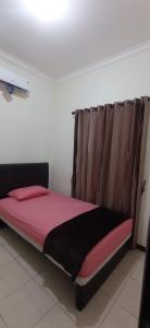 een bed in een kamer met een rode deken en een raam bij COZY TO STAY TEBET (PENGINAPAN MURAH,TP GA MURAHAN) in Jakarta