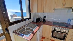 una pequeña cocina con fregadero y microondas en En el centro de Benidorm y con vistas al mar, en Benidorm