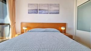 1 dormitorio con 1 cama grande y 2 lámparas en En el centro de Benidorm y con vistas al mar, en Benidorm