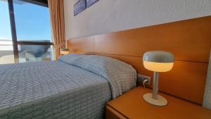 sypialnia z łóżkiem i lampką na stole w obiekcie En el centro de Benidorm y con vistas al mar w mieście Benidorm
