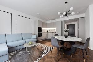 uma sala de estar com um sofá azul e uma mesa em The Amberlyn Suite Hotel em Budapeste