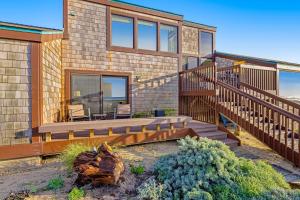 uma casa com um deque de madeira e escadas em Monterey Dune Dream em Moss Landing