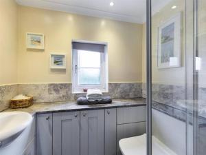 uma casa de banho com um WC, um lavatório e um chuveiro em Two Bedroom Cottage (rural setting with good Access links) em Grantham