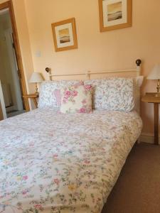 a bedroom with a large bed with flowers on it at Two Bedroom Cottage (rural setting with good Access links) in Grantham
