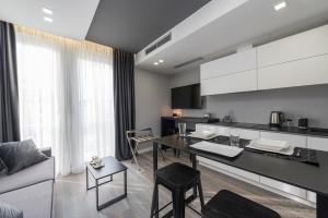 a kitchen and living room with a table and a couch at Artis Accommodation Lux in Zadar