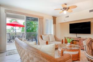 a living room with a tv and a couch and a table at Ali'i Cove B1 in Kailua-Kona