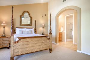 a bedroom with a four poster bed and a mirror at Ali'i Cove B1 in Kailua-Kona +20 photos