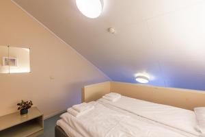 un letto in una camera con due luci sul soffitto di Namsskogan Familiepark & Hotell a Trones