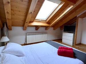 Un dormitorio con una gran cama blanca y una ventana en Ca La Rougvie, en Esterri d'Àneu
