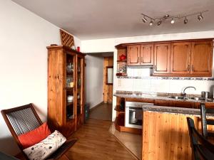 a kitchen with wooden cabinets and a counter top at Ca La Rougvie in Esterri d'Àneu