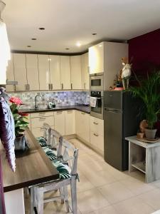 kuchnia z białymi szafkami i stołem z krzesłami w obiekcie Vivienda Vacacional Vaiana w mieście Las Rosas +25 zdjęć