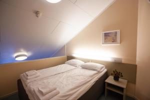mały pokój z łóżkiem z ręcznikami w obiekcie Namsskogan Familiepark & Hotell w mieście Trones