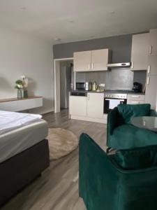 ein Schlafzimmer mit einem Bett und einem Sofa sowie eine Küche in der Unterkunft Ferienwohnungen am Luitpold in Berchtesgaden