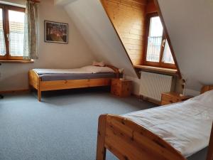 1 dormitorio en el ático con 2 camas y ventanas en Ferienhaus zur Altmühl en Ornbau