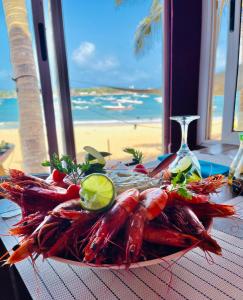 a plate of lobsters on a table with a view of the beach at La Cabane du Pêcheur Atlantic Evasion in Dakar