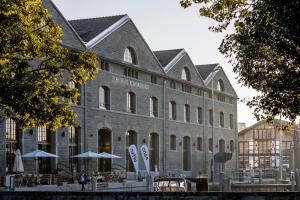 a large brick building with tables and umbrellas at Appartements am See in Romanshorn
