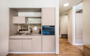 a kitchen with white cabinets and a sink at Appartements am See in Romanshorn