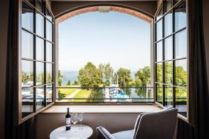 a room with a large window with a table and chairs at Appartements am See in Romanshorn