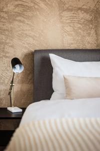 un lit avec une lampe sur une table à côté de celle-ci dans l'établissement Appartements am See, à Romanshorn