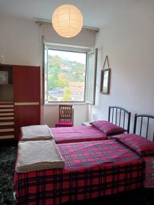 een slaapkamer met 2 bedden en een groot raam bij Comoda posizione, per 5-TERRE, PortoVenere, Lerici in La Spezia