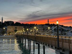 a bridge over the water with a city at sunset at Dbe apartment LA SIRENA in Francavilla al Mare