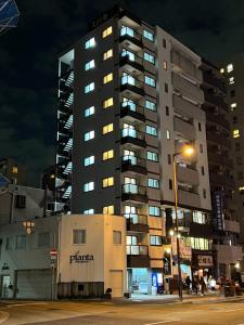 大阪市にあるGN98 Saiwaicho Osakの夜間の高層アパートメントで、通りの光が差し込みます。