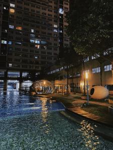 a swimming pool in a city at night at Le Thompson - Puchong Center IOI Mall in Puchong