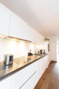 a kitchen with white cabinets and stainless steel appliances at -Zentrale Wohnung-Balkon-Desingerküche- in Bielefeld