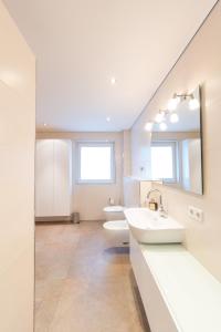 ein Badezimmer mit 2 Waschbecken und 2 WCs in der Unterkunft -Zentrale Wohnung-Balkon-Desingerküche- in Bielefeld