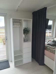 - une chambre avec un lit et un placard blanc dans l'établissement K39, à Laholm