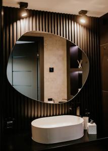 a bathroom with a round mirror and a sink at Mały domek z balią kąpielową in Długosiodło