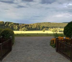 un vialetto con una recinzione con un campo sullo sfondo di WenneQuartier a Schmallenberg