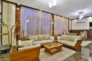 Una sala de estar con sofás y una mesa de café. en فندق بفن Puffin Hotel, en Al Nairyah
