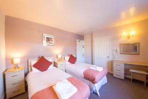 um quarto de hotel com duas camas e uma televisão em Dalesgate Hotel - Self Check In em Keighley