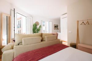 a bedroom with a bed and a couch at Hostly Acetres 2A-Penthouse in City Center-Fibre-Parking Opt in Seville