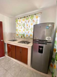 cocina con nevera de acero inoxidable y fregadero en 2023 Apartamento Amoblado Múltiple Nogales, en Santa Marta
