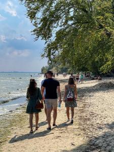 un hombre y dos chicas caminando por la playa en Redlowskie Klify Apartments en Gdynia