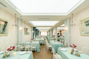 a dining room with blue tables and white chairs at Pensiunea Acasa in Sibiu