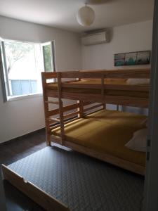 pokój z dwoma łóżkami piętrowymi i oknem w obiekcie Villa climatisée avec piscine w mieście Sari-Solenzara