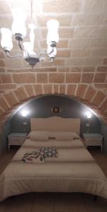 una camera con un grande letto con un muro di mattoni di Palazzo Saraceno apartments-Antica mangiatoia a Taranto