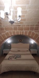 una camera da letto con un letto grande con un muro di mattoni di Palazzo Saraceno apartments-Antica mangiatoia a Taranto